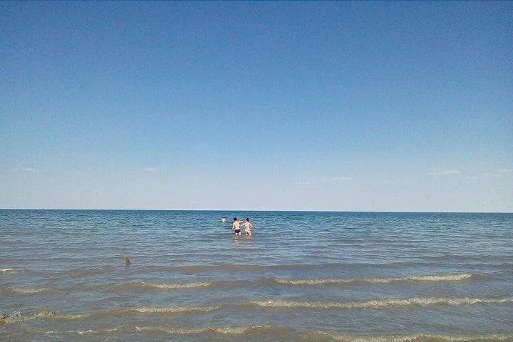 People wading in the blue waters of the Aral Sea