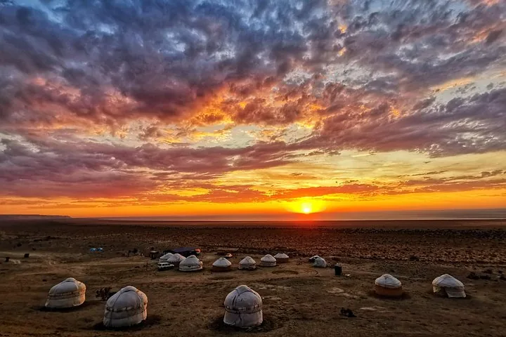 A stunning sunset over a yurt camp near the receding shoreline of the Aral Sea.